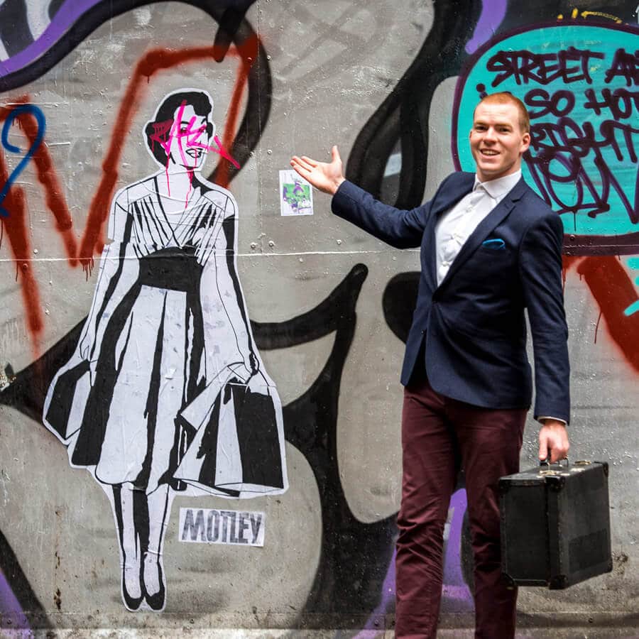 award winning magician sam fitton poses in front of street art in manchester
