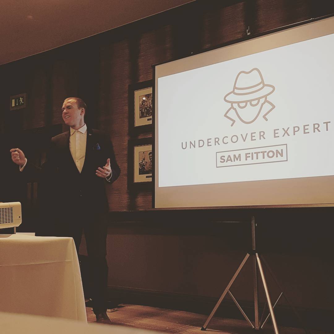 sam fitton speaks at a corporate event as the undercover expert